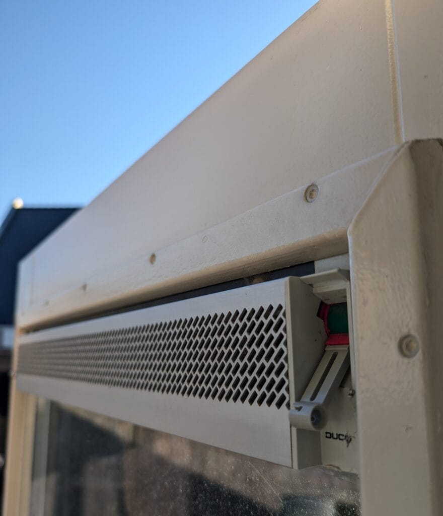 Detail foto van achterdeur van hout met ventilatierooster